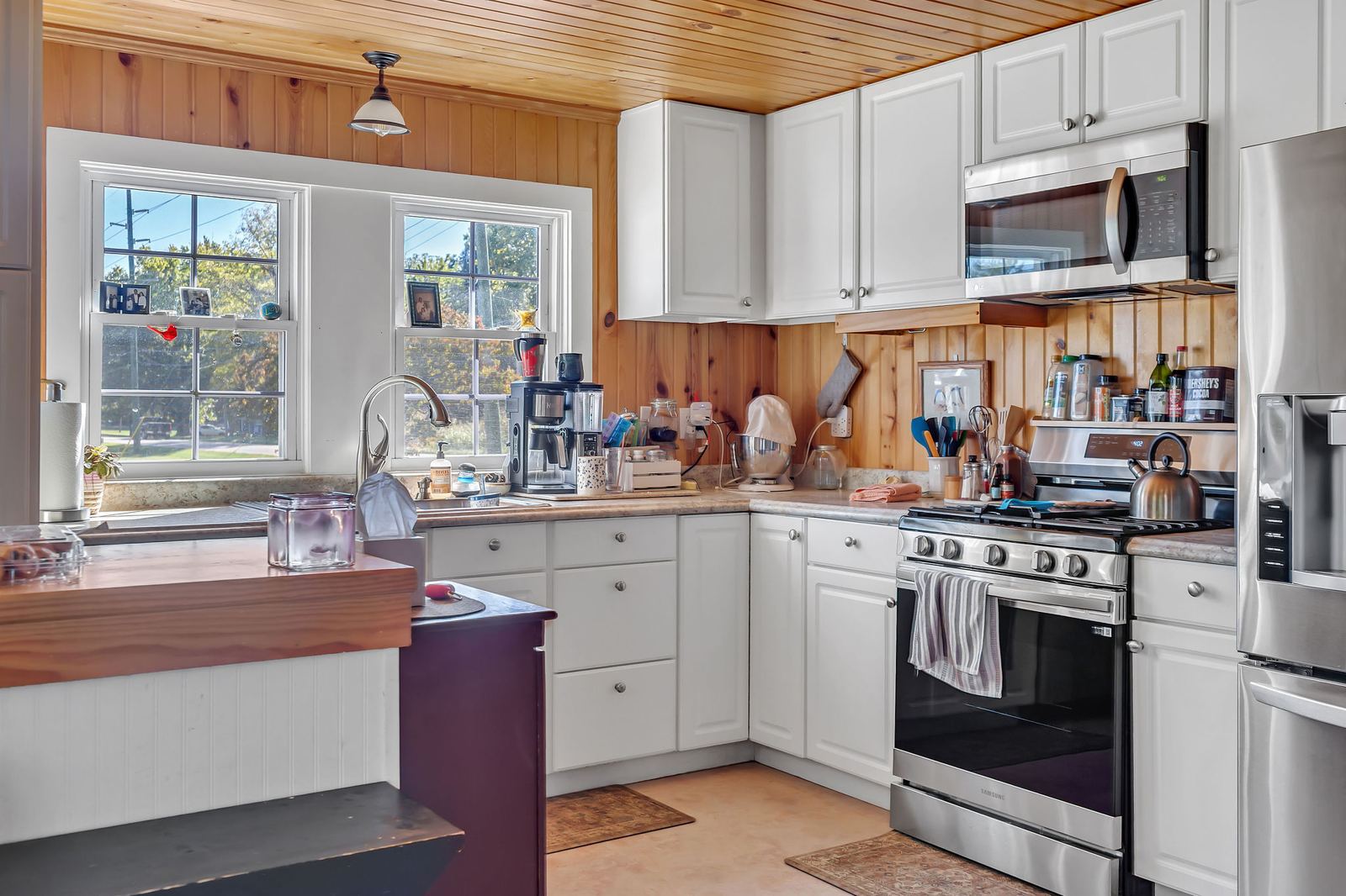 Kitchen with white cabinets, wood accents, and a stainless range
