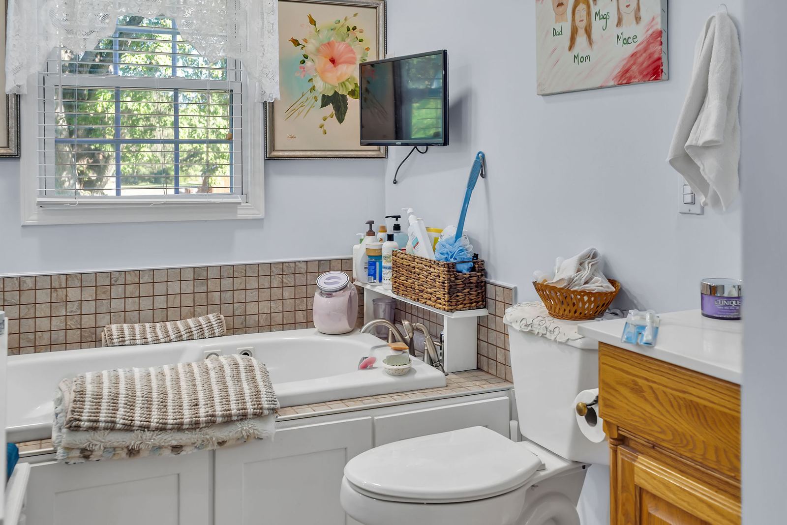 Full bath with a jetted tub and a window
