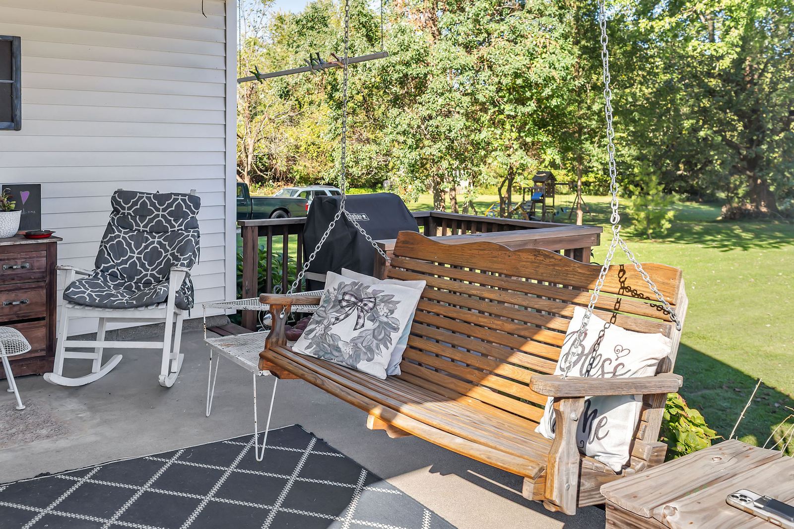 Covered back porch with a porch swing and rocking chairs